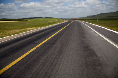 Empty road along countryside landscape