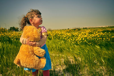 Woman with yellow flowers on field