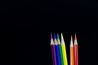 Close-up of colored pencils against black background