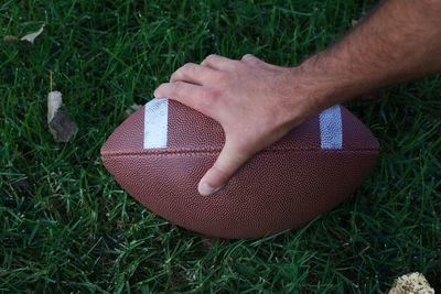 Close-up of man hand on grass