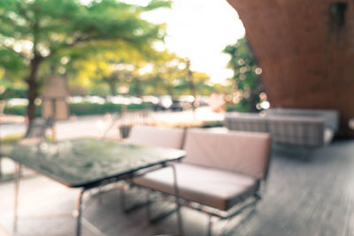 Empty chairs and tables in swimming pool against building