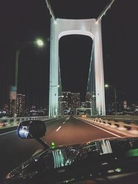 Illuminated bridge in city against sky at night