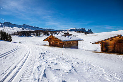 Houses on snow covered field against sky