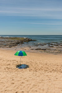 High angle view of parasol at sandy beach against sky