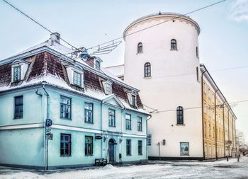 Low angle view of buildings in town against sky