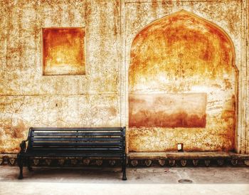 Empty bench against wall