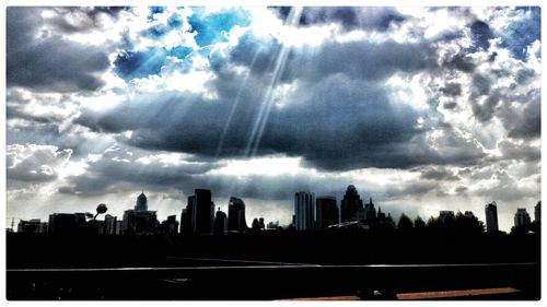 Cityscape against cloudy sky