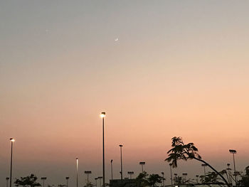 Silhouette street lights against clear sky at sunset