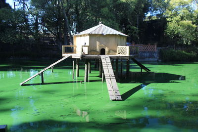 Built structure in lake against trees