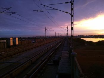 Railway tracks against sky at sunset