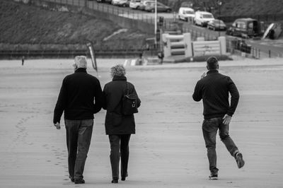 Full length rear view of woman standing against white wall