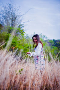 Woman standing on field against sky