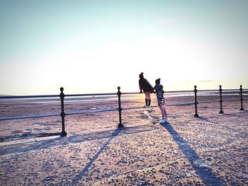 People on beach against clear sky