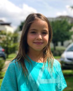 Portrait of cute girl at yard during sunny day