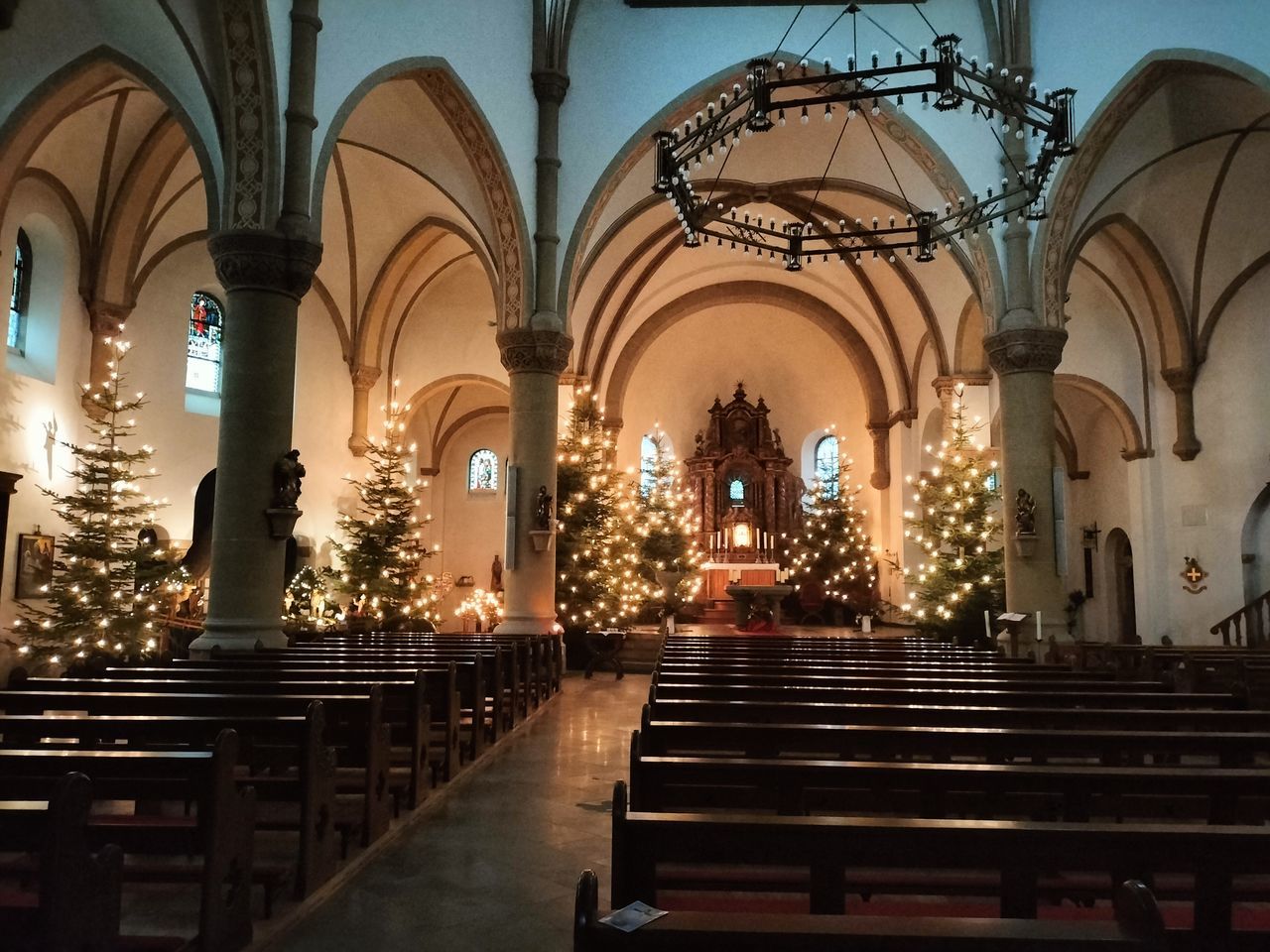 architecture, built structure, religion, place of worship, belief, spirituality, building, arch, pew, catholicism, indoors, worship, bench, no people, staircase, seat, illuminated, travel destinations, altar, aisle, candle, lighting equipment