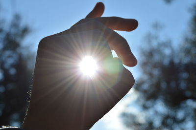 Low angle view of hand holding sun