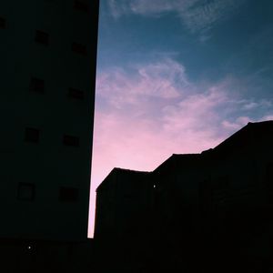 Low angle view of silhouette buildings against sky at sunset