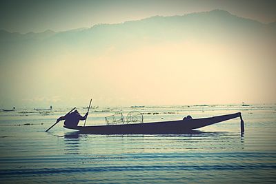 Boats in sea at sunset