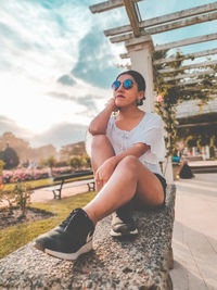 Young woman wearing sunglasses sitting outdoors