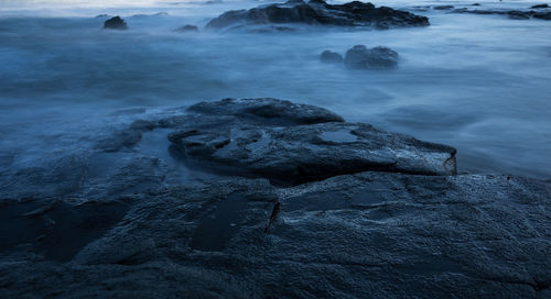 Close-up of rocks in sea against sky