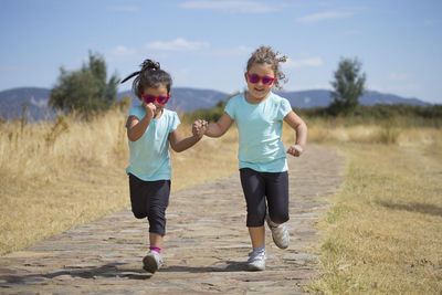 Full length of happy woman running on field