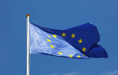 Low angle view of european union flag against blue sky