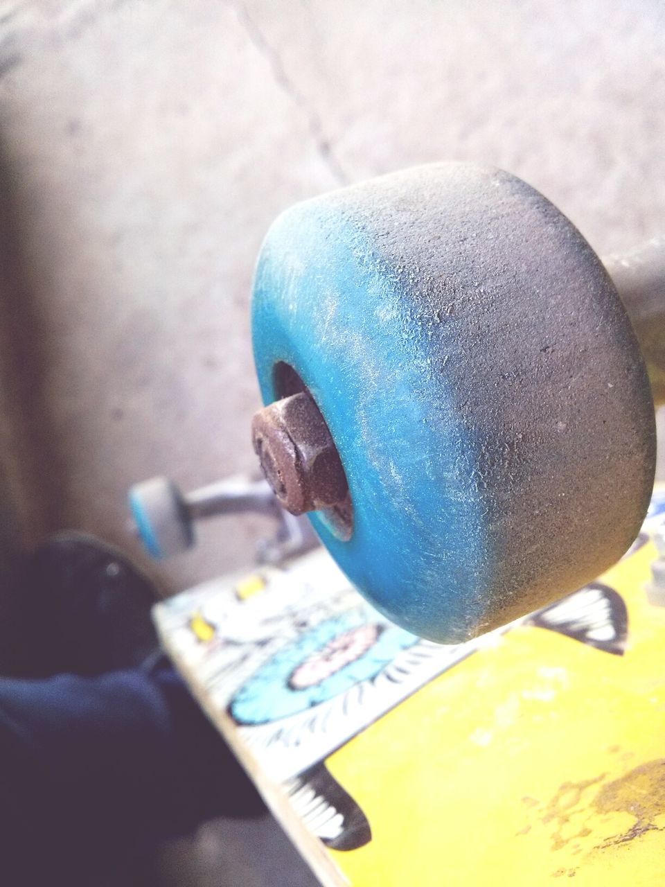 close-up, indoors, still life, focus on foreground, blue, table, food and drink, communication, single object, selective focus, no people, day, part of, holding, yellow, metal, high angle view, western script, text, toy