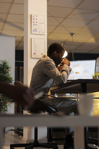 Side view of woman sitting on table