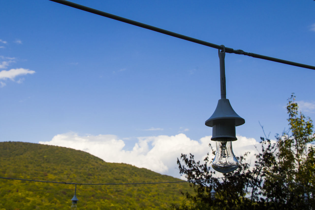 LOW ANGLE VIEW OF STREET LIGHT AND MOUNTAIN AGAINST SKY