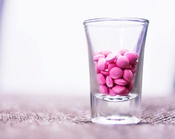 Close-up of glass of pink water on table