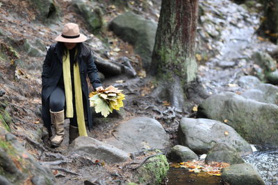 Rear view of woman standing in forest