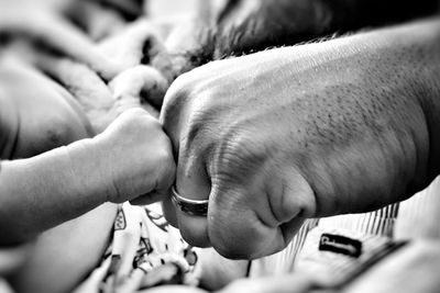 Cropped image of father and baby boy doing fist bump