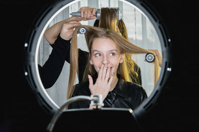 Portrait of young woman with reflection in mirror