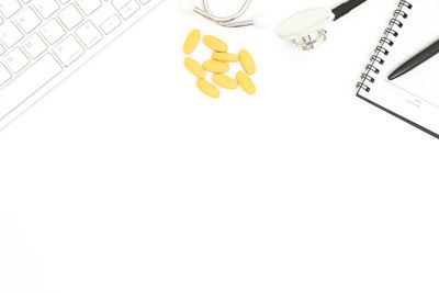 High angle view of yellow paper on white background