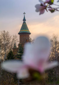 Temple by building against sky during sunset