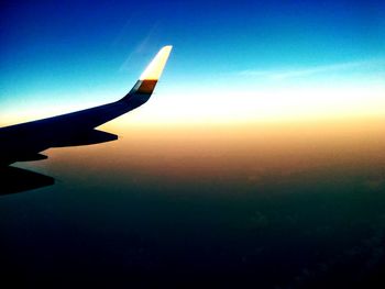 Cropped image of airplane flying over cloudscape