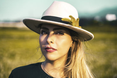 Close-up portrait of young woman wearing hat