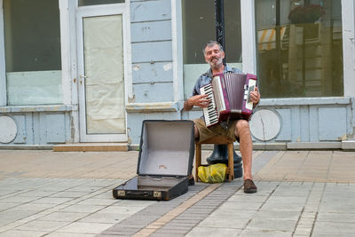 Full length of man sitting on seat