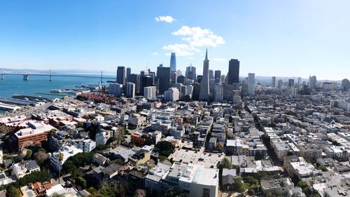 Aerial view of cityscape by sea against sky