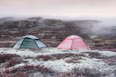 Tent on field by mountain against sky