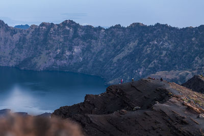 Rock formations by mountains against sky