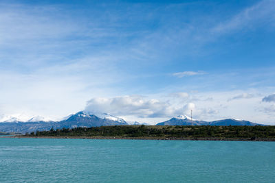 Scenic view of lake by mountains against sky