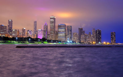 Illuminated buildings against sky at night