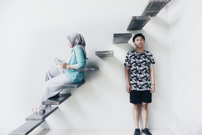 Young woman standing against wall