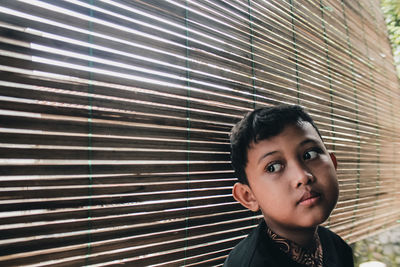 Portrait of young boy looking through window