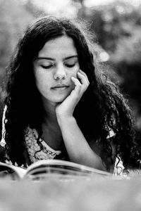 Teenage girl reading book at park
