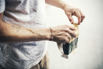 Midsection of carpenter closing oil can at workshop