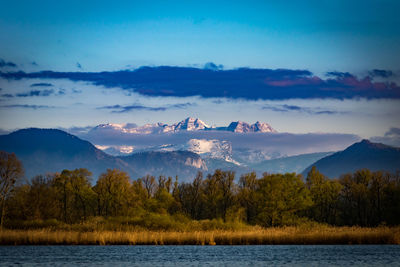 Scenic view of chiemsee lake by mountains against sky