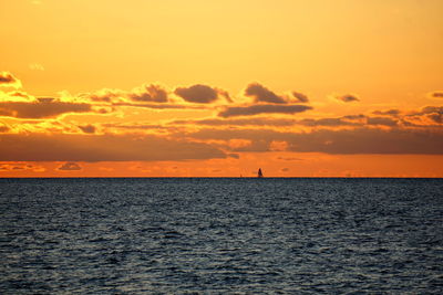 Scenic view of sea against dramatic sky during sunset