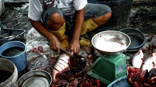 Low section of fish vendor cutting fish